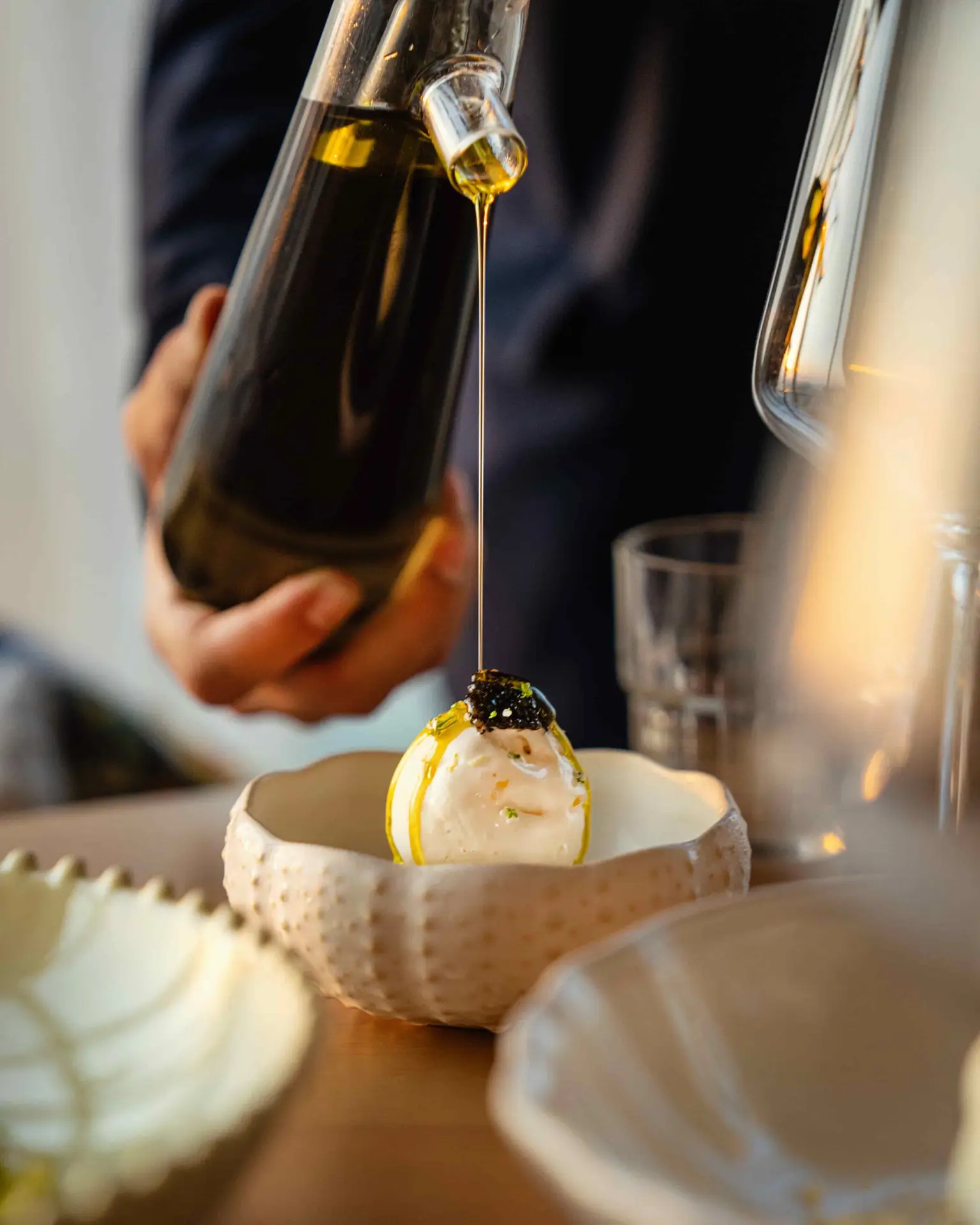 Chef Saradhi Dakara opens Orilla in JVT, Dubai. Experience a unique MediterrAsian menu, sustainable design featuring recycled oyster shells, and soulful coastal vibes.