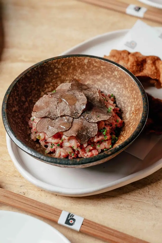 The update introduces "The Basics," a section that places seafood front and centre to celebrate precise preparation. This category includes options like buttery Hamachi and classic Sake handrolls, where the purity of the fish is the primary focus. For guests seeking a more decadent meal, there is an option to add caviar to these selections. A significant addition to the menu is "Owan’s," a bowl-focused category designed for those seeking richer textures and comforting portions. Standout dishes in this section include the Otoro and Caviar Bowl, the Japanese Wagyu and Caviar Bowl, and a mixed Sake, Hamachi, Akami, and Ikura Bowl. These bowls are prepared with the same attention to detail that defined the original handroll menu, providing a more substantial alternative for midday dining or evening meals.
